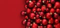 Christmas decorations, top view of pile of glass balls colored in red, isolated on red background, useful as a greeting gift card