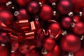 Christmas decorations, top view of pile of glass balls colored in red, with ribbon bow useful as a greeting gift card background