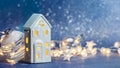 Christmas decorations with toy house, glass ball and glowing lights on blue background Royalty Free Stock Photo