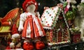 Christmas decorations in toy shop window including traditional red ragdoll and Gingerbread house