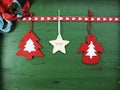 Christmas decorations on vintage green wood background, with hanging felt ornaments.