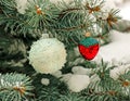 Christmas decorations white ball and strawberries hang on a snow-covered branch of a Christmas tree on a festive background of Royalty Free Stock Photo