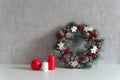 Christmas decorations: wreath and candles on gray background. Cozy holiday interior Royalty Free Stock Photo