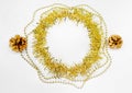 Christmas decorations of yellow and golden color on a white background - chain of balls, beads, round circle of tinsel, two bumps. Royalty Free Stock Photo