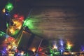 Christmas decorative lights. Christmas garland lights on wood. Colorful Xmas light bulbs on rustic brown plank Royalty Free Stock Photo