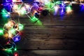 Christmas decorative lights. Christmas garland lights on wood. Colorful Xmas light bulbs on rustic brown plank Royalty Free Stock Photo