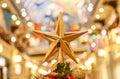 A Christmas decorative - star on the top of A Christmas tree with a beautiful bokeh background Royalty Free Stock Photo