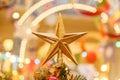 A Christmas decorative - star on the top of A Christmas tree with a beautiful bokeh background Royalty Free Stock Photo