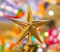 A Christmas decorative - star on the top of A Christmas tree with a beautiful bokeh background Royalty Free Stock Photo