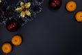 Christmas decorative wreath, fir tree decor and tangerines on black background. Winter Holiday season backdrop Royalty Free Stock Photo