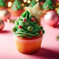 Christmas delicious cupcake with green whipped cream and star on pink background. Xmas homemade dessert