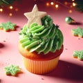 Christmas delicious cupcake with green whipped cream and star on pink background. Xmas homemade dessert