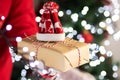 Christmas delivery,Courier holds a gift in his hands on the background of lights and christmas tree Royalty Free Stock Photo