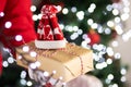 Christmas deliveryman holds a gift in his hands on the background of lights and christmas tree