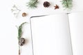 Christmas desktop stationery mock-up scene. Closeup of blank notebook. Frame of acorn, pine cones fir branches and