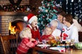 Christmas dinner. Family with kids at Xmas tree. Royalty Free Stock Photo