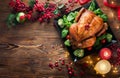 Christmas Dinner. Roasted chicken. Winter Holiday table served, decorated with candles and xmas baubles Royalty Free Stock Photo