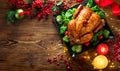 Christmas Dinner. Roasted chicken. Winter Holiday table served, decorated with candles and xmas baubles Royalty Free Stock Photo