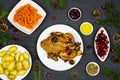 Christmas dinner. Traditional roasted chicken, vegetables and seasoning decoration on black background Royalty Free Stock Photo