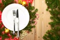 Christmas Dinner - white plate with cutlery on wooden background