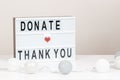 Christmas donation, charity. White lightbox with message Donate and Thank you standing on the table. Front view, close