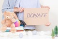 Christmas donation, holiday charity concept. Kid and woman hands holding brown piece of cardboard with inscription Royalty Free Stock Photo