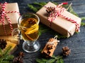 Christmas drink grog with lemon, cinnamon, wine on wooden table with gift boxes for holiday