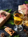 Christmas drink grog with lemon, cinnamon, wine on wooden table with gift boxes for holiday