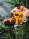 Christmas drink grog with lemon, cinnamon, wine on wooden table with gift boxes for holiday