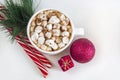 Christmas drink: hot chocolate with marshmallows in a cup among red decorations on a white background. Christmas, winter holidays Royalty Free Stock Photo
