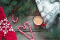 Christmas drink. Mug hot coffee with milk, red candy cane on the wooden background. New Year. Holiday card. Rustic style. Top view Royalty Free Stock Photo