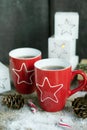 Christmas drink.Tea or coffee in red mugs on wooden table with candy cane. Royalty Free Stock Photo