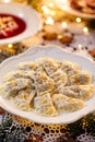 Christmas dumplings stuffed with mushroom and cabbage on a white plate on a holiday table.