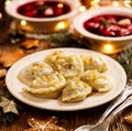 Christmas dumplings stuffed with mushroom and cabbage on a white plate on a wooden table.