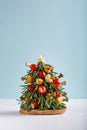 Christmas edible tree made from cheese, vegetables and sprigs of rosemary. New Year food background, food art concept. Copy space