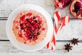 Christmas eggnog oatmeal with crushed candy cane, pomegranates and chocolate chips, table scene over white wood Royalty Free Stock Photo