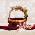 Christmas empty basket with festive decorations, glowing garland and scarf on a background of lights. Christmas design template. Royalty Free Stock Photo