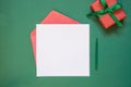 Christmas empty blank letter to Santa or invitation with giftbox on green. Top view Royalty Free Stock Photo