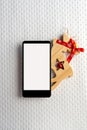 Christmas empty mobile phone on red background, Holiday planning and wooden reindeer on white background
