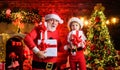 Christmas eve. Amazed Santa Claus and child with Christmas present. Family holidays and childhood. Little kid and