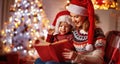 Christmas Eve. family mother and baby reading magic book at home Royalty Free Stock Photo