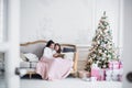Christmas Eve. family mother and child daughter reading magic book at home on a sofa near Christmas tree Royalty Free Stock Photo