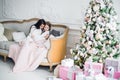 Christmas Eve. family mother and child daughter reading magic book at home on a sofa near Christmas tree Royalty Free Stock Photo