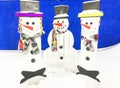 Christmas Eve, Winter day with snowfall. Snowmen made of wood stand in a snowdrift in the evening, on a blue background Royalty Free Stock Photo