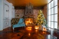 Christmas evening by candlelight. classic apartments with a white fireplace, decorated tree, sofa, large windows and