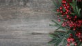 Christmas Evergreen Branches and Berries Over Rustic Wood Horizontal Background