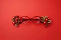 AI generated. Christmas eye glasses with decoration of spruce branches and balls toy on a red festive background