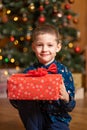 Christmas fabulous, little boy holding a big red box with a present from Santa