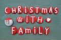 Christmas with Family, creative text composed with red colored stone letters and a stone Santa Claus