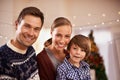 Christmas, family and happy child with parents in home for love, connection and bonding at festive celebration with Royalty Free Stock Photo